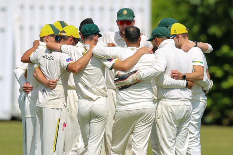 Wokingham Cricket Club huddled together after taking a wicket.